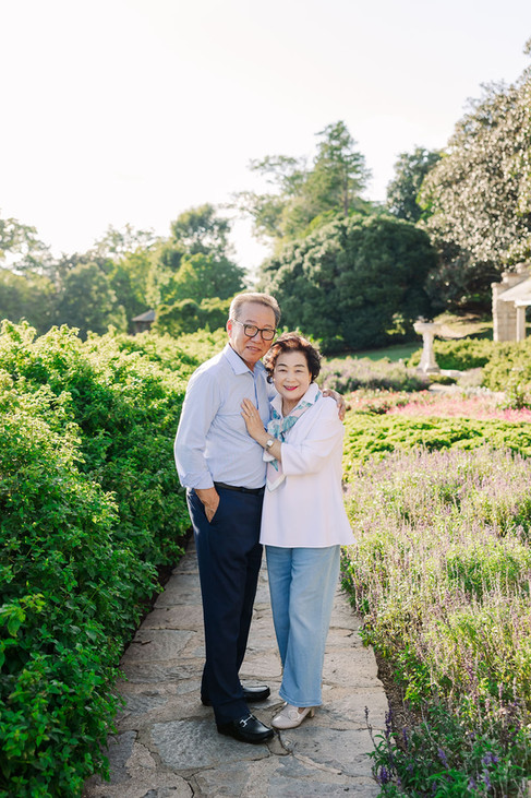 Grandparents smiling and holding hands during their family photoshoot at Maymont Park in Richmond, Virginia.