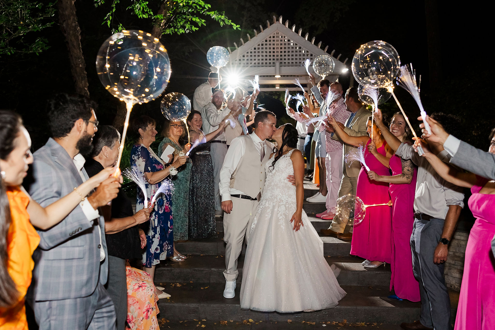 	5.	Bride and groom happily exiting their reception, surrounded by guests holding glowing balloon lights.