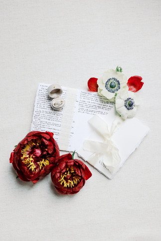 4. Bridal detail flat lay with pearl jewelry, red florals, white gloves, invitation details, and wedding accessories