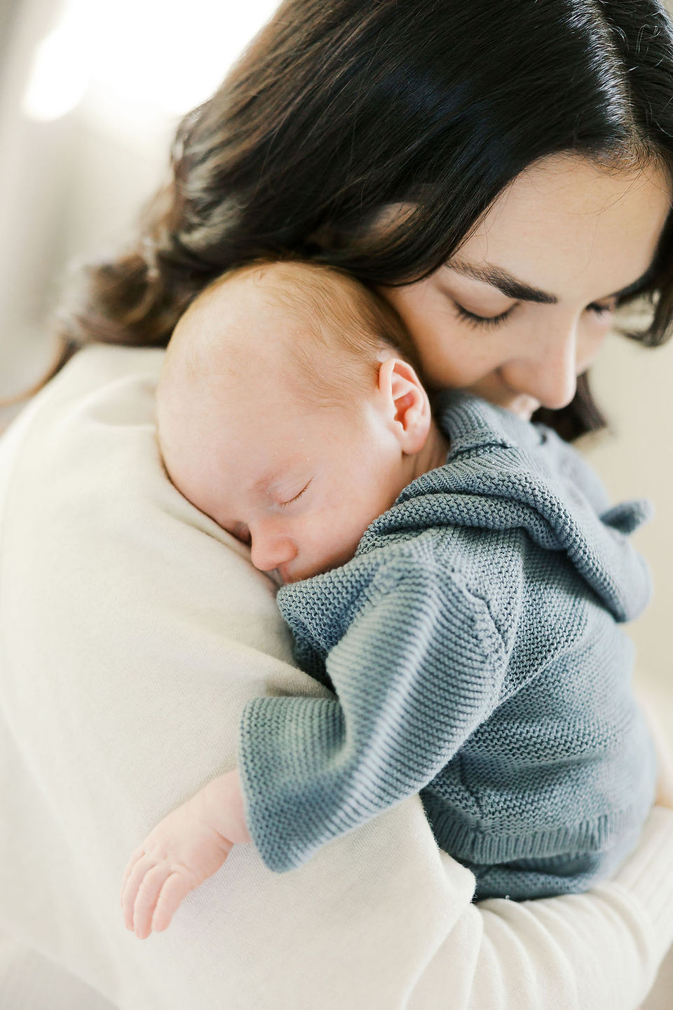 Mother gently holding her sleeping newborn baby during a lifestyle newborn photography session in Richmond