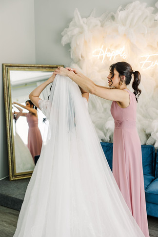 18. Bride adjusting veil with help from bridesmaid — heartfelt getting ready photo by Richmond wedding photographer.