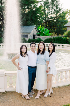 Father and daughters smiling in soft light, captured at the Maymont fountain by Richmond Photographer Munhoz Photography.