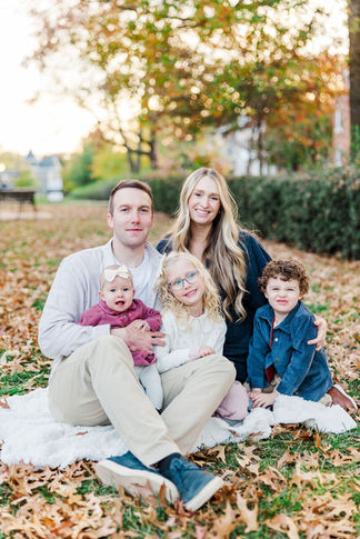 family smiling and looking at the camera during a fall family session in RVA