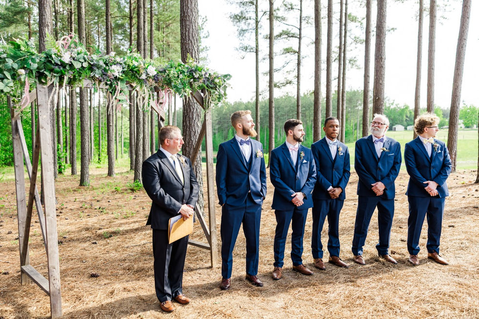 2. Groomsmen waiting under pine trees at outdoor altar