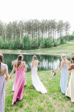 6. Bridesmaids walking joyfully by water at spring wedding