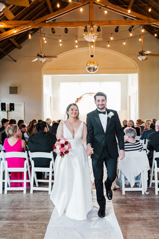 Bride and groom smiling as they exit the ceremony space at The Schoolhouse at Hawthorne in Richmond, VA.