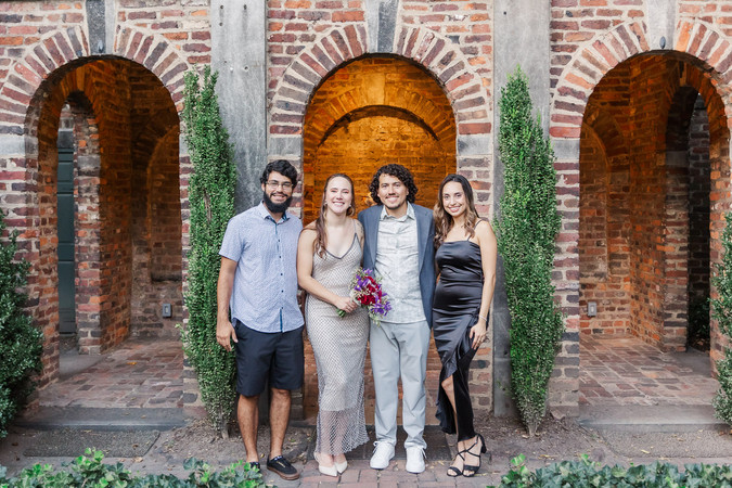 6. Bride and groom standing with two family members, all dressed elegantly.