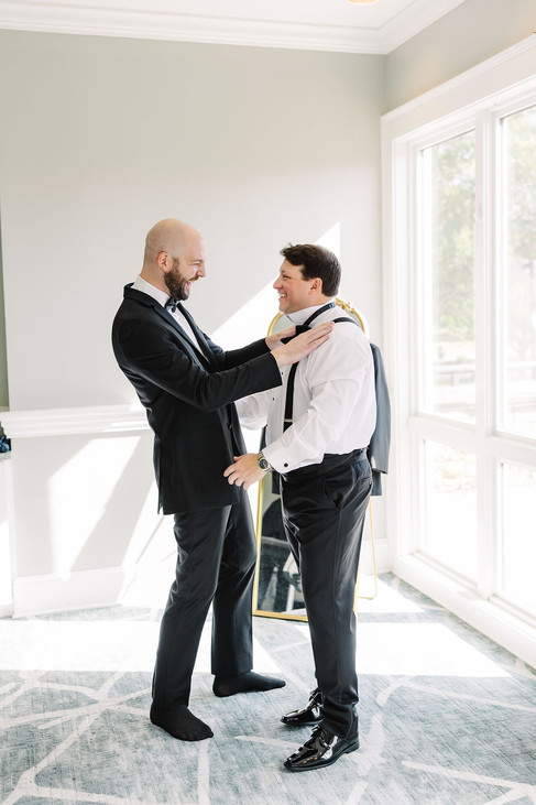 13. Groomsman helping groom with jacket before ceremony — candid Richmond wedding photographer moment at The Dominion Club.