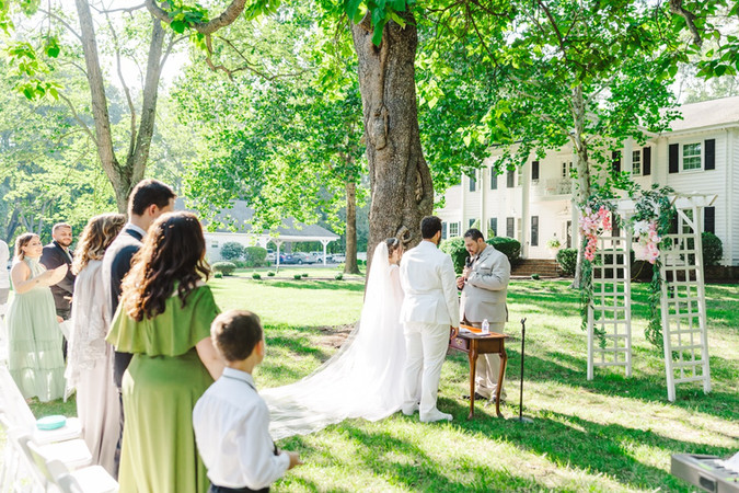 	14.	“Bride and groom exchanging vows under large oak tree at The Virginia Cliffe Inn wedding”