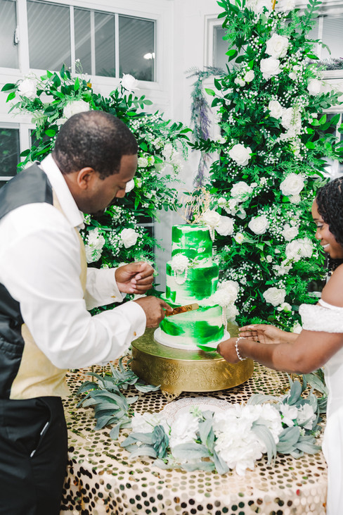 3. Groom cutting the wedding cake while bride laughs beside him at Richmond VA wedding.