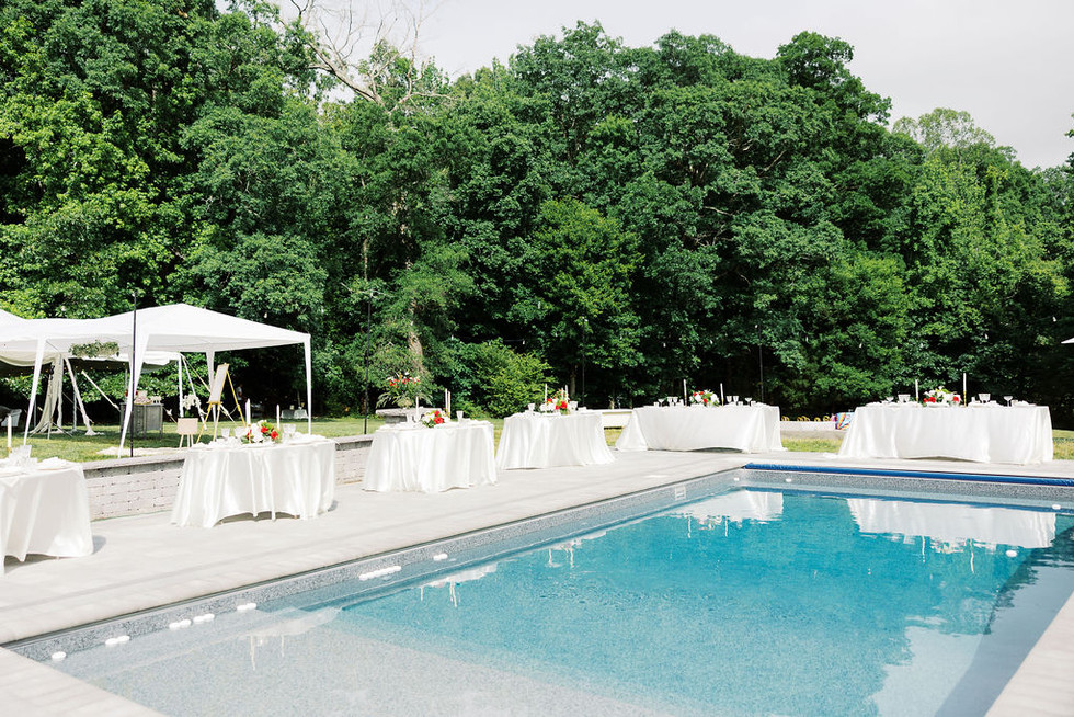 10. Outdoor poolside wedding reception with white linens, candlelight, and greenery at a private residence