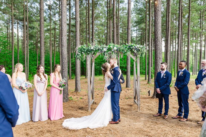 9. Bride and groom exchanging vows at rustic wooden altar