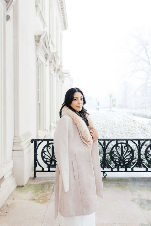 1. bride standing on balcony during snowy winter wedding at VMFA in Richmond Virginia