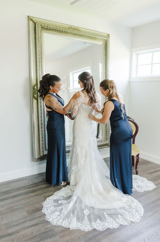 	6.	Bride receiving help from two bridesmaids while getting ready in bridal suite