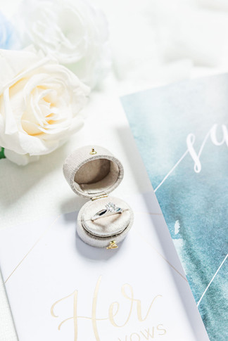 4. Bride’s wedding ring in a velvet box with vow book and white rose