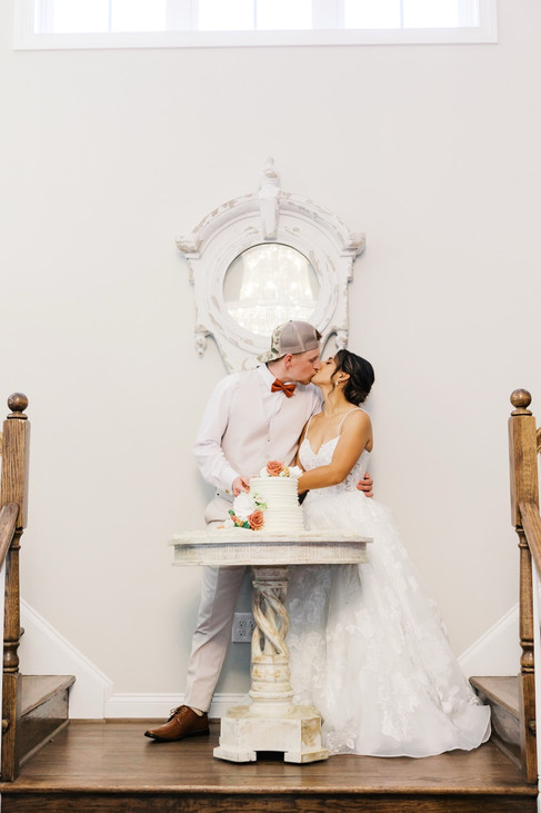 18. Bride and groom kissing near wedding cake at Antebellum of New Kent