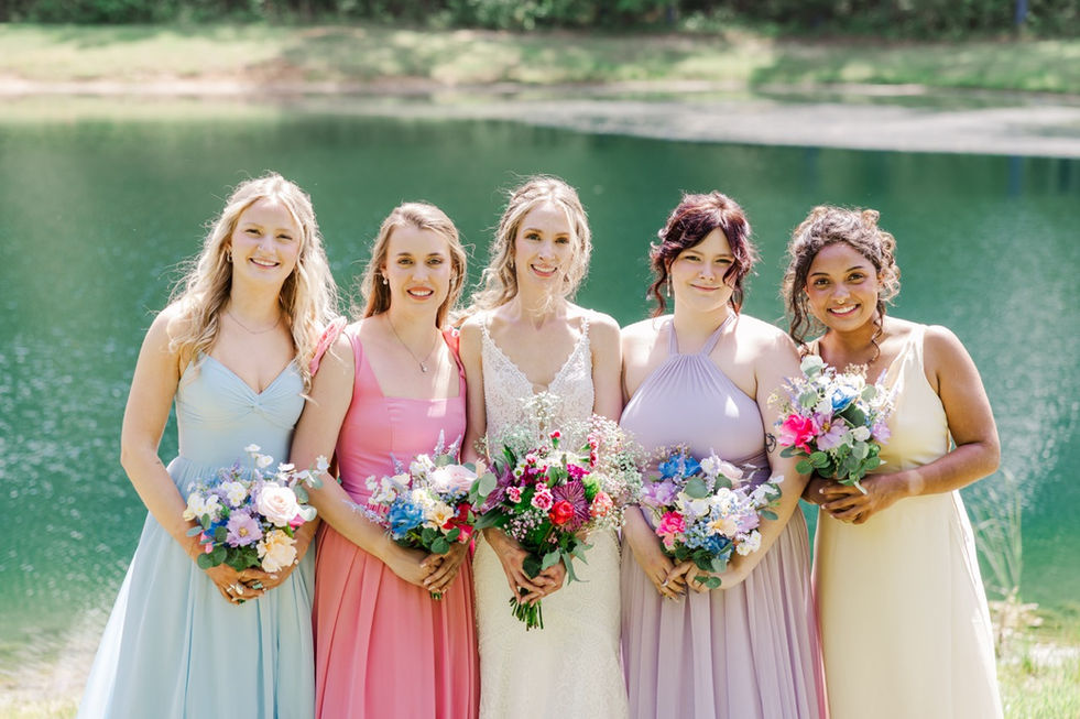 5. Bridesmaids in mismatched pastel dresses holding bouquets