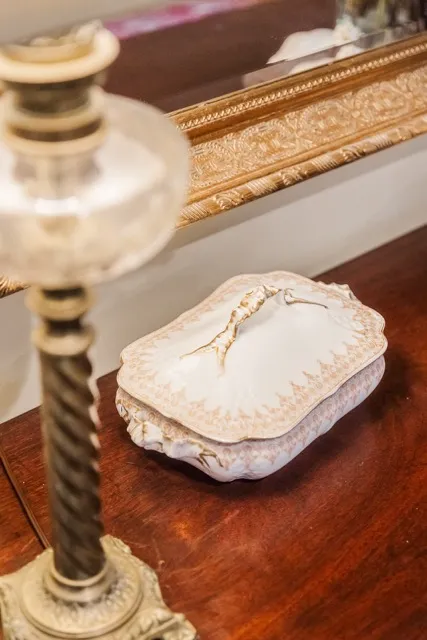 	10.	Close-up of a vintage ring pillow placed on a wooden table, adding a delicate wedding touch.