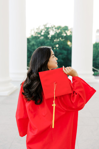 48. Gabi putting on red graduation gown during VCU senior photos
