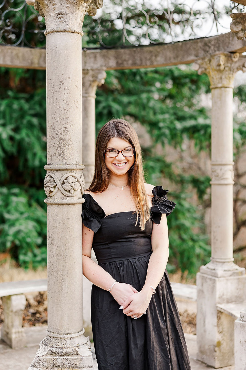 Bride standing elegantly among Maymont Park columns.