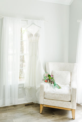 13. Wedding dress with bouquet on white chair in bridal suite