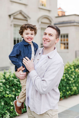 Father and son smiling and embracing during a joyful family session at the VMFA in Richmond, Virginia.