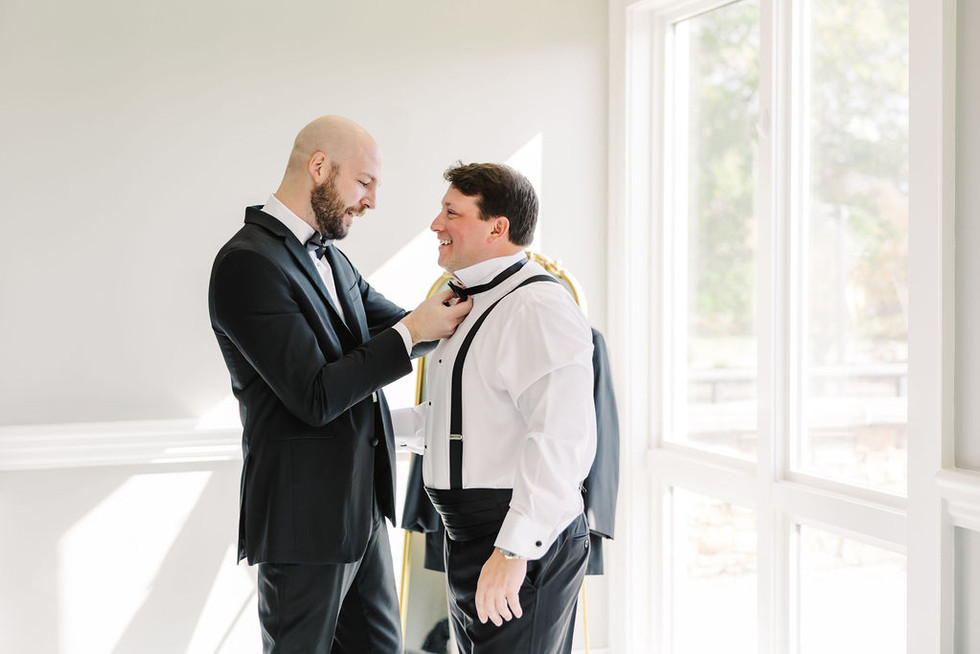 15. Final touches before the wedding as groomsman straightens groom’s tie — captured by Richmond wedding photographer.
