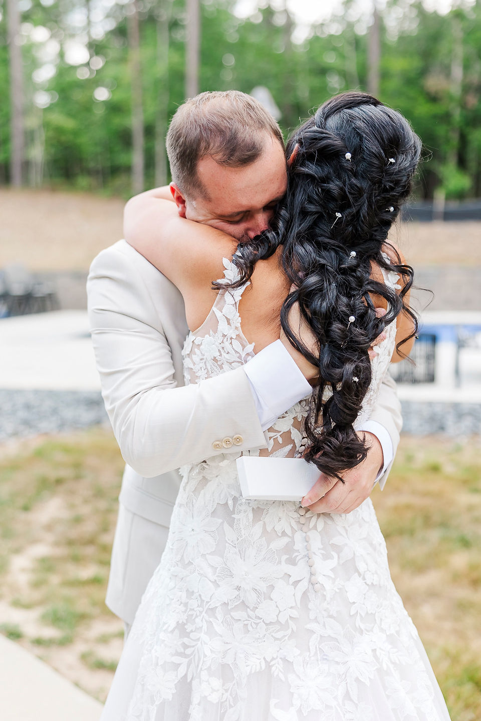 	3.	Bride and groom sharing a heartfelt embrace during their first look outdoors.