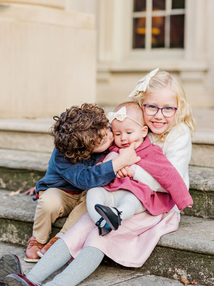 Siblings cuddling their younger sister during family portraits in Richmond, VA.
