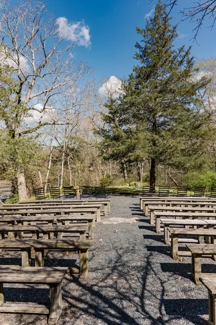 	3.	Open-air wedding ceremony setup with wooden benches and a natural backdrop at The Mill at Fine Creek.