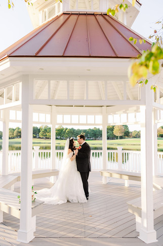 15️⃣ Bride and groom standing by lakeside greenery with flowing veil — elegant fine-art wedding portrait at The Dominion Club.