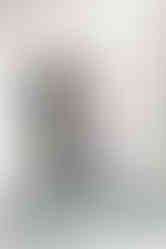 9. Groom seated near window adjusting suspenders — pre-ceremony preparation photo at The Dominion Club.