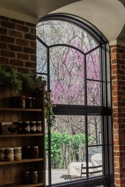 	18.	Stained-glass window framed by exposed brick, adding character and elegance to the venue.