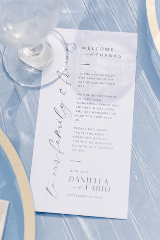 A close-up of a wedding reception menu with calligraphy details, placed on a beautifully styled table setting.