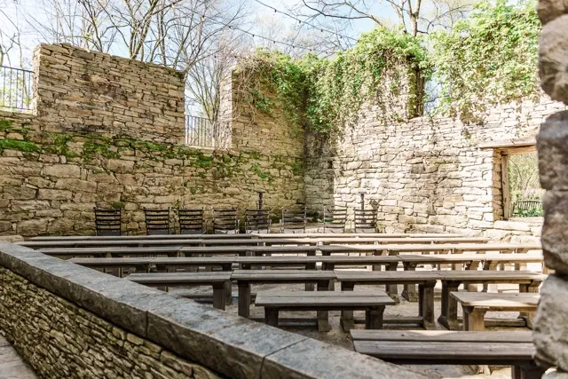 	12.	Ceremony space at The Mill at Fine Creek featuring rustic stone walls, wooden benches, and an open-air setup.
