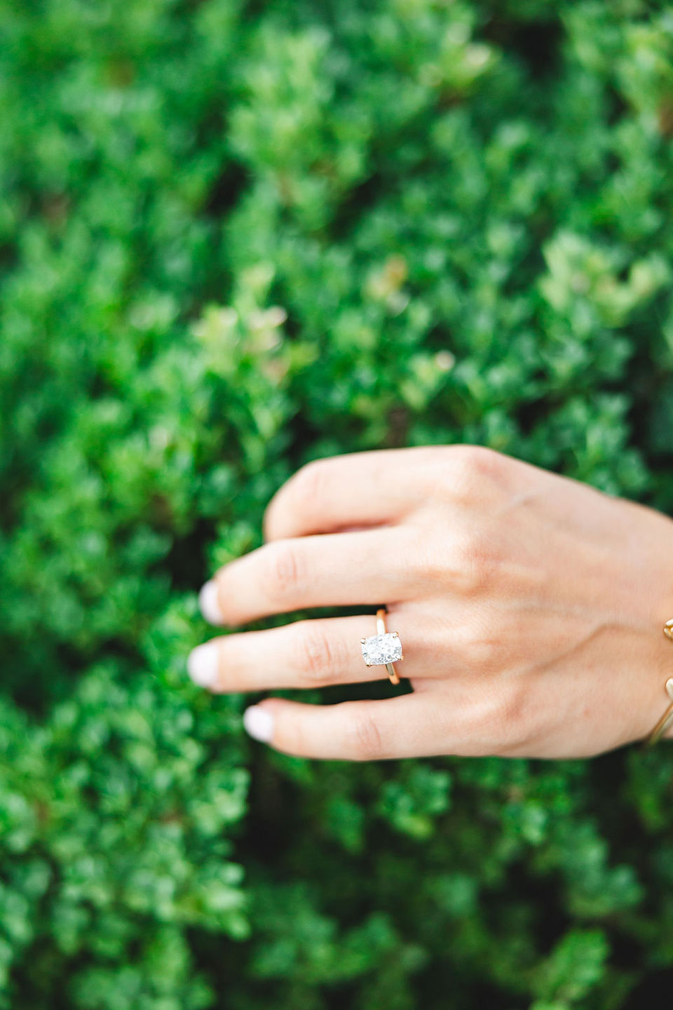 	5.	Close-up of groom holding fiancée’s hand with engagement ring in focus.