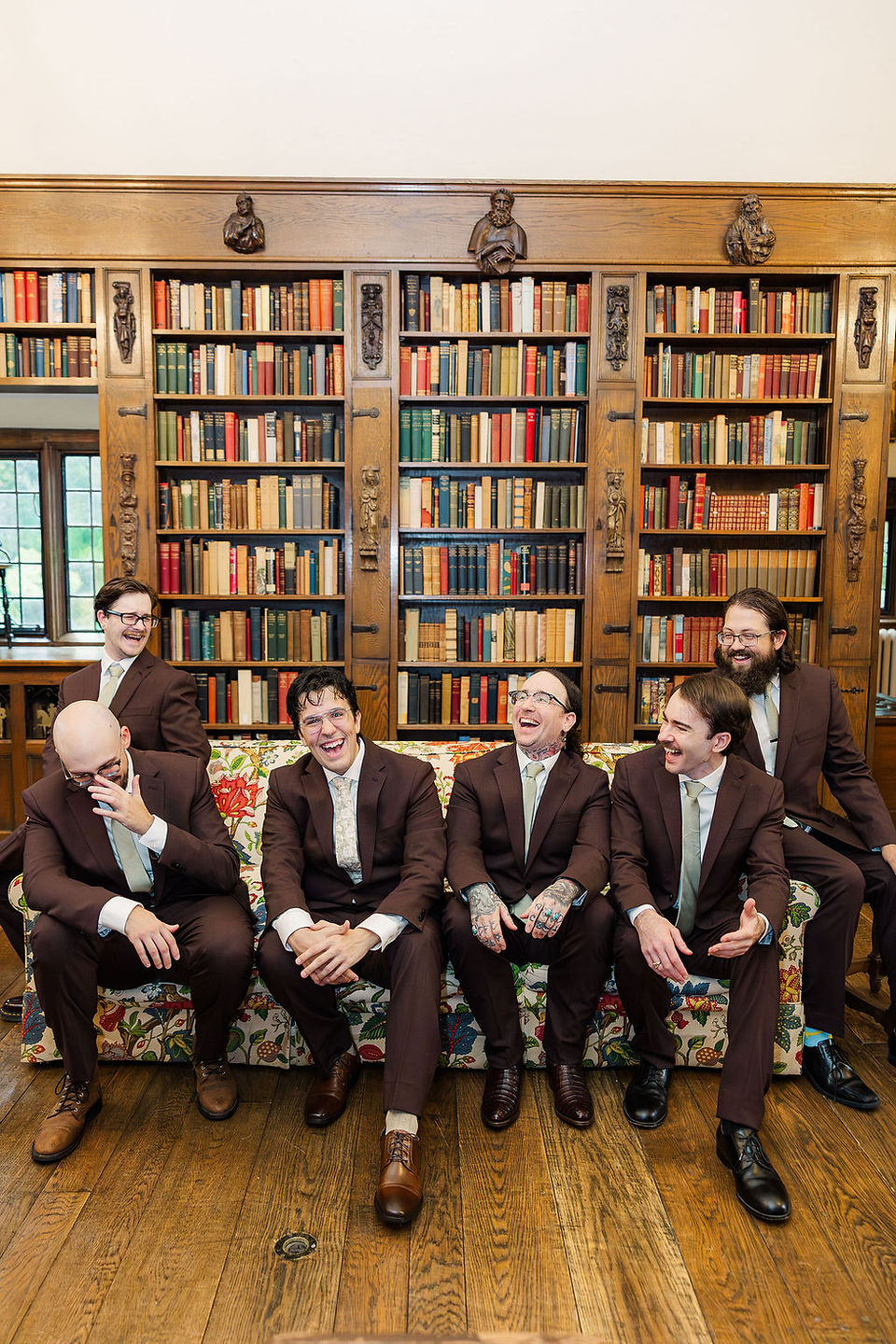 	9.	Groom buttoning suit jacket in front of bookshelf