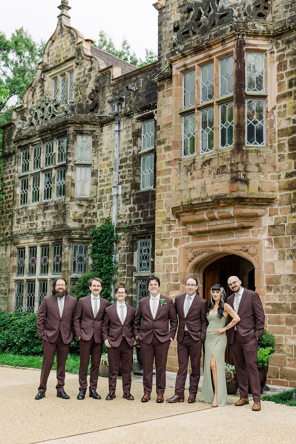 	11.	Groom smiling in front of grand venue entrance with groomsmen