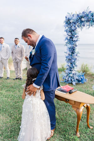 Heartwarming moment as the groom kneels down to hug the flower girl at the altar during their Virginia Beach wedding ceremony.apher in Cape Charles, VA | Virginia Wedding Photography