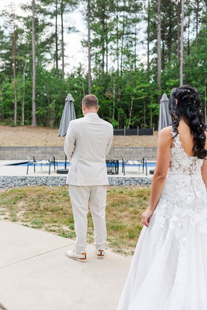 17. Bride approaching the groom outdoors for their first look at The Boathouse at Sunday Park.