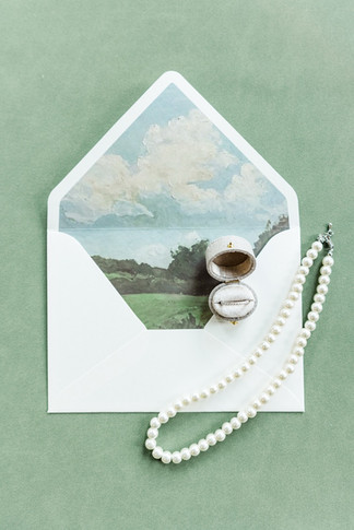 	3.	Flat lay with envelope, pearl necklace, and invitation