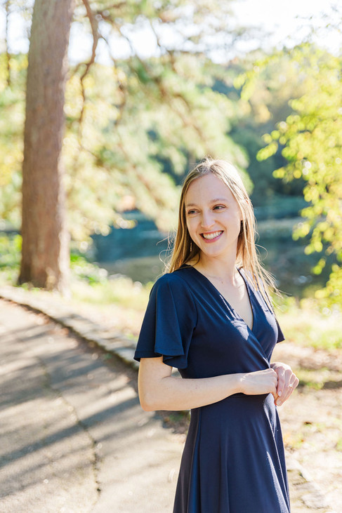 Bride-to-be posing in a navy blue dress, smiling.