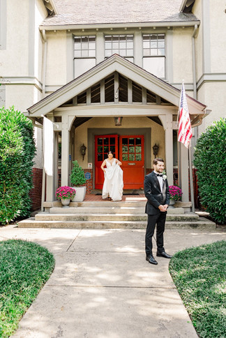 Bride walking towards the groom for their first look outside the wedding venue.