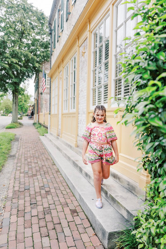 	5.	Young girl walking down brick sidewalk with trees and shutters