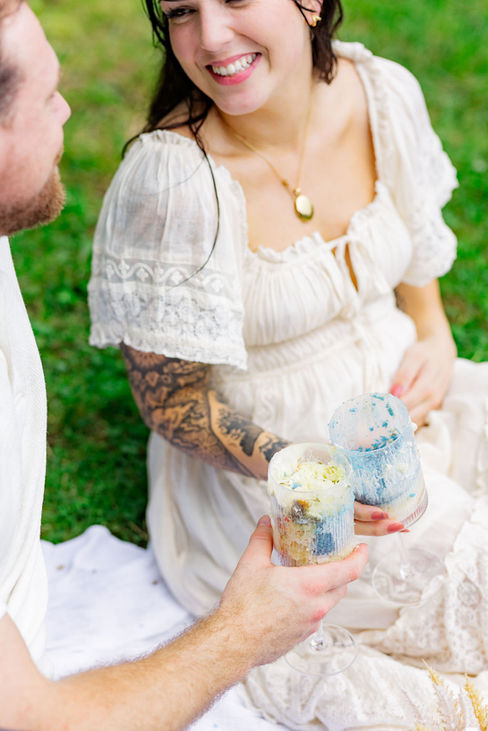 Mom-to-be holding cupcake with baby blue frosting — sweet detail from Northern Virginia gender reveal picnic.