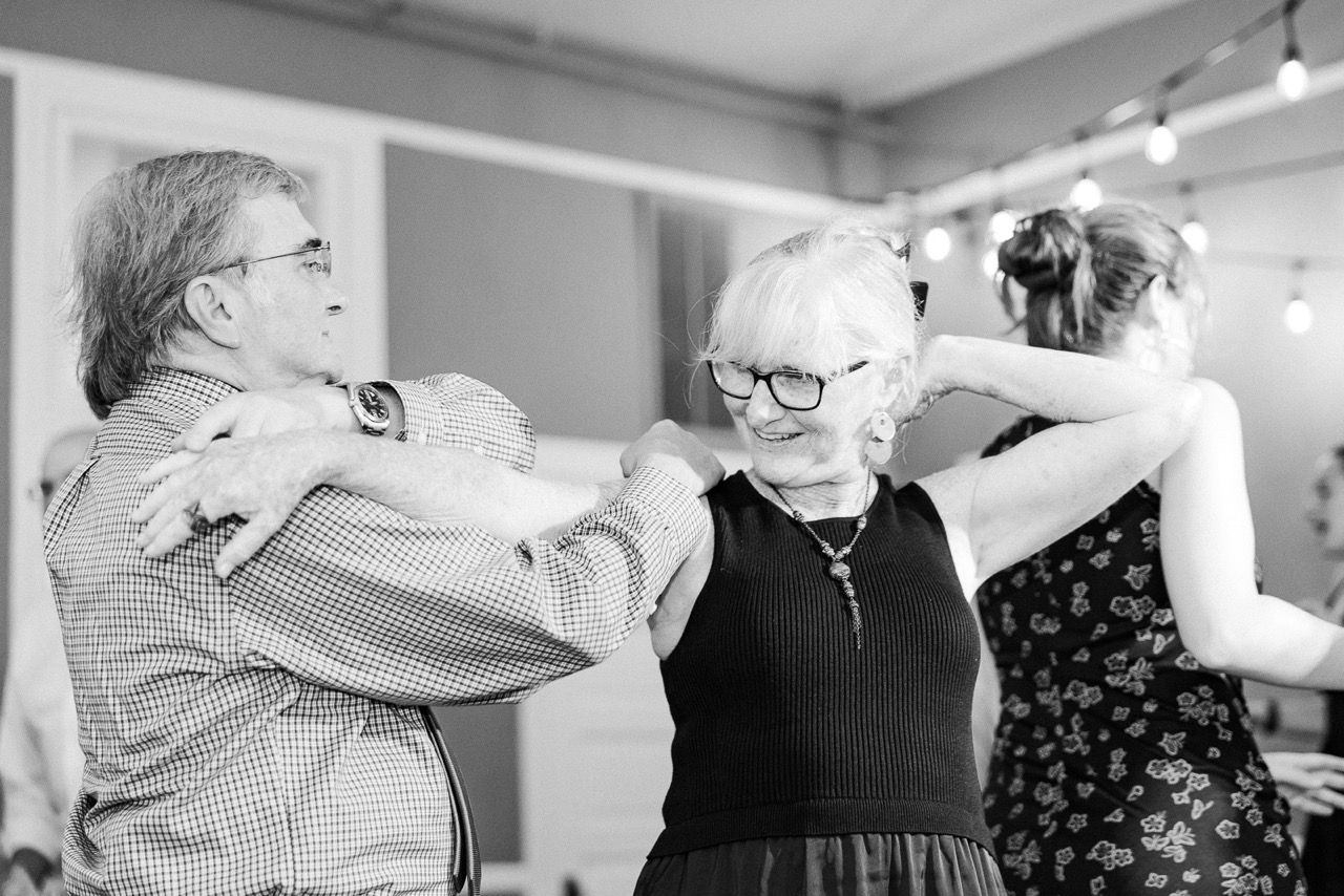 Black and white photo of an elderly couple dancing joyfully at a wedding in Richmond, VA.