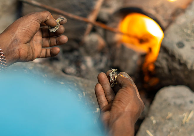 artisan melting solid brass pieces in a furnace