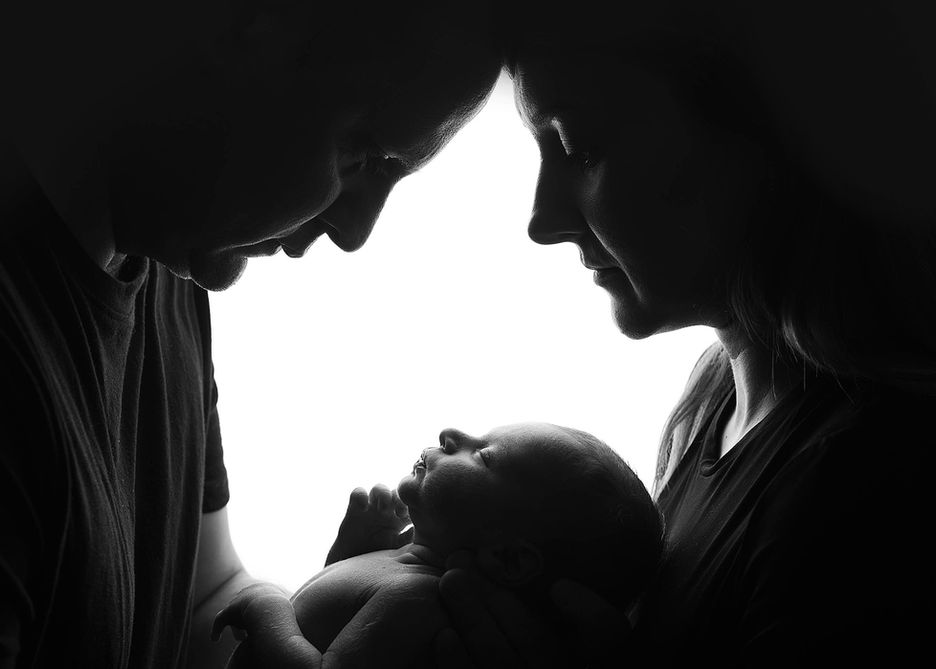 noworodek w czułych objęciach rodziców na naturalnej sesji noworodkowej w Plewiskach