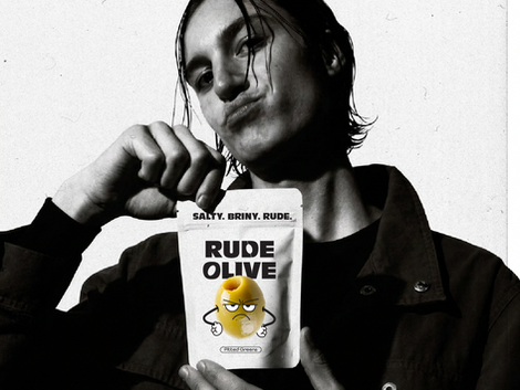 A sarcastic man holding a package of olives with the rude olive branding on it.