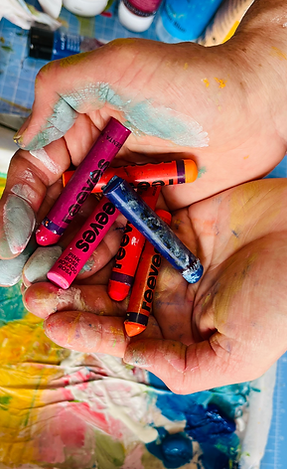 photo of a handful of oil pastels over a painting table